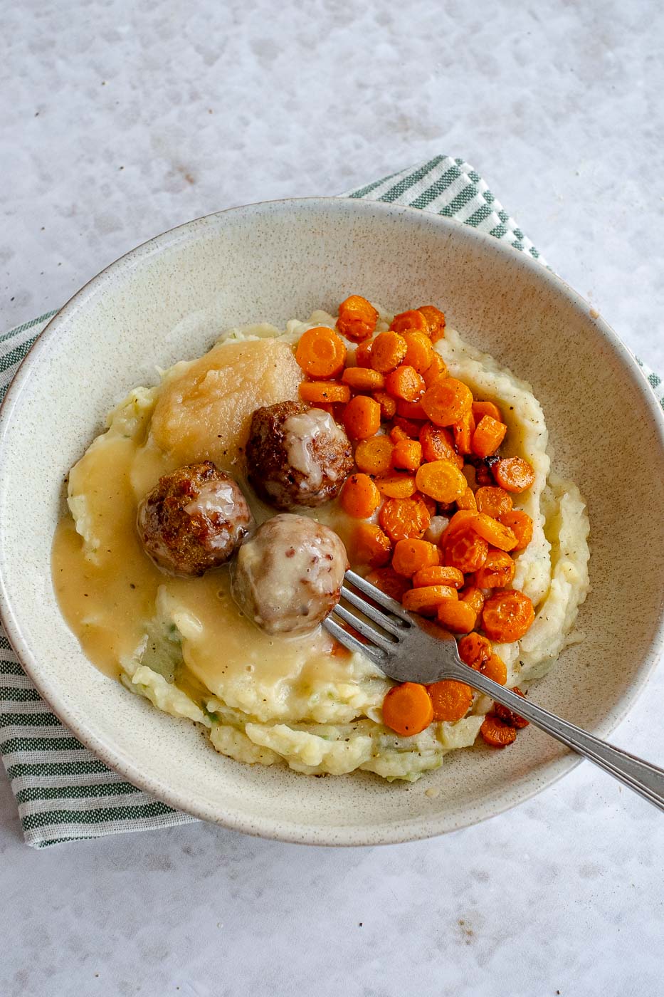 1. Preipuree met geroosterde worteltjes en gehaktballen in een diep bord met een vork